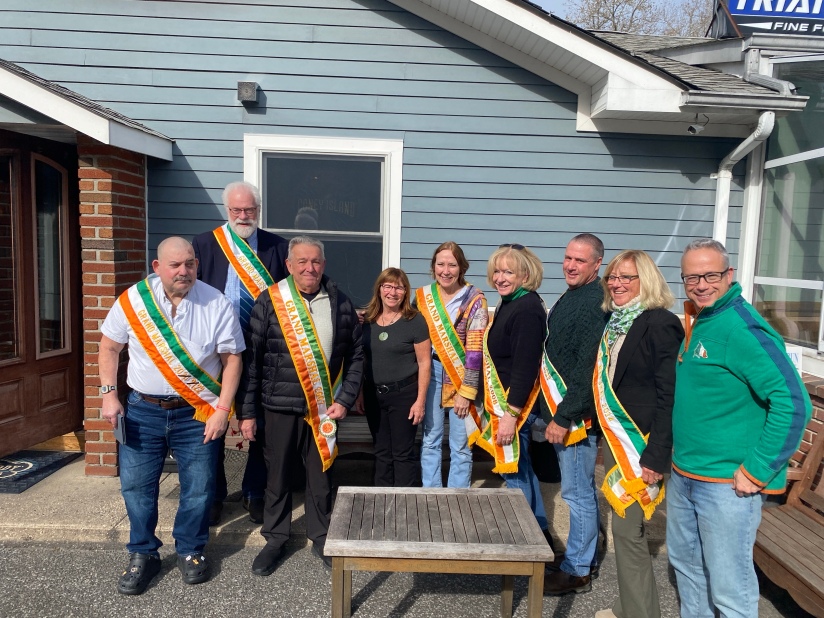 Standing with Patty, fourth from left, are past Grand Marshals with the parade, including Parade Committee President, Tim Laube, at right